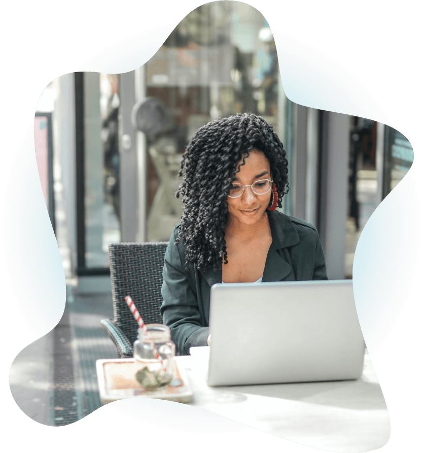 A woman behind a laptop with a light smile