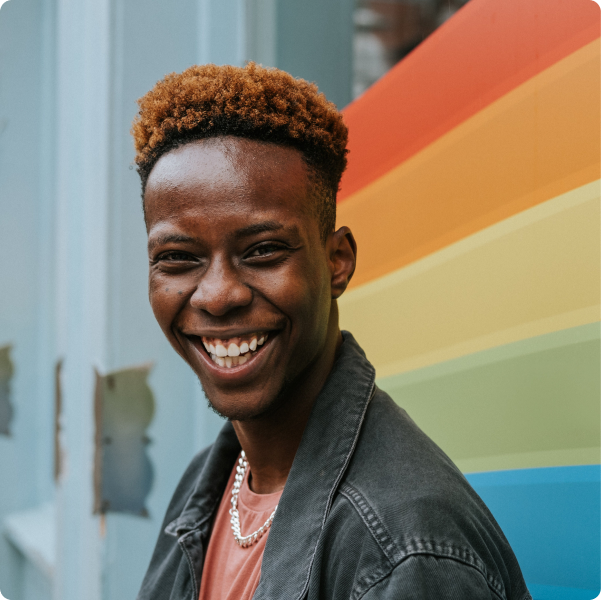 Health Loft dietitians for food allergies Man smiling in front of a rainbow colored wall