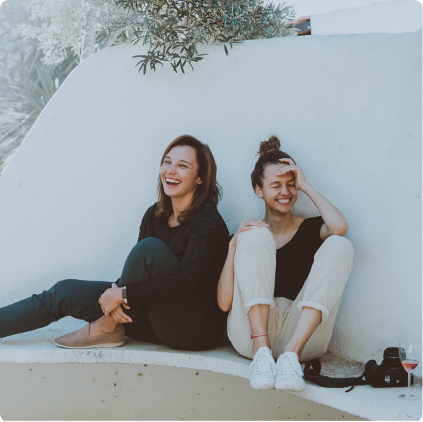 Health Loft dietitians for eating disorders Two women sitting by a wall laughing