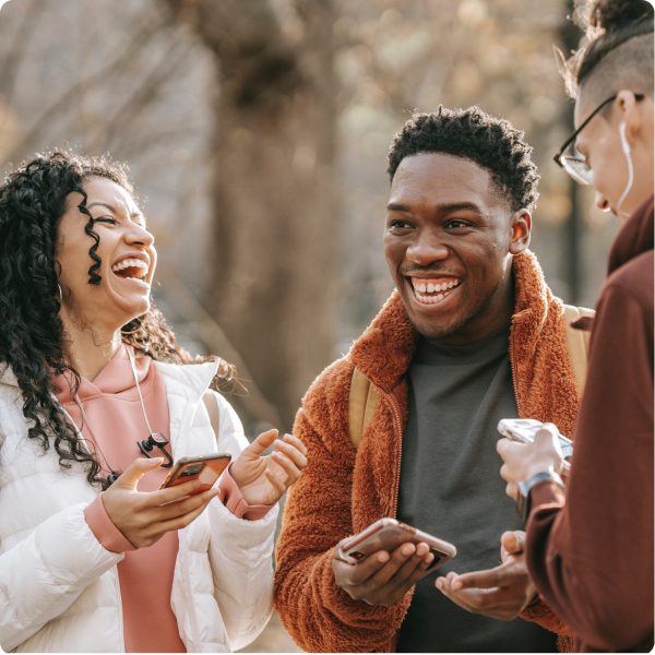 Health Loft dietitians for emotional eating People standing in a group with their phones, laughing and smiling