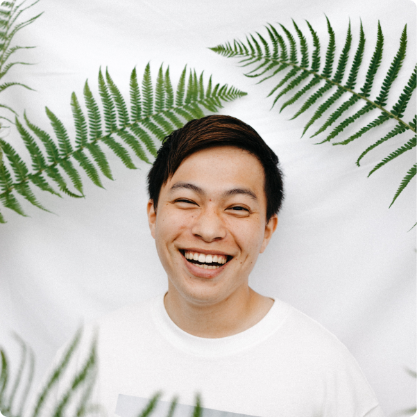 Health Loft dietitians for GI & gut health A young man smiling next to green plant leaves