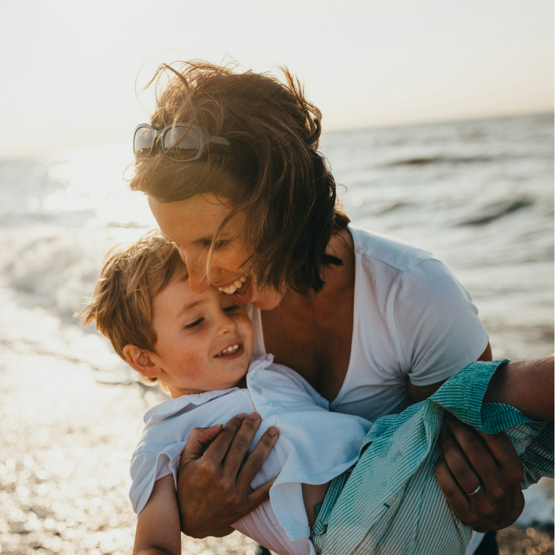 A woman and child happy on the beach